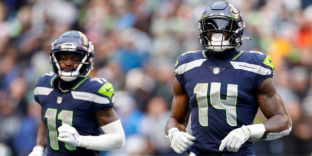 Marquis Goodwin, #11, and DK Metcalf, #14, of the Seattle Seahawks jog for their positions during the 3rd quarter against the Carolina Panthers at Lumen Field on December 11, 2022 in Seattle.