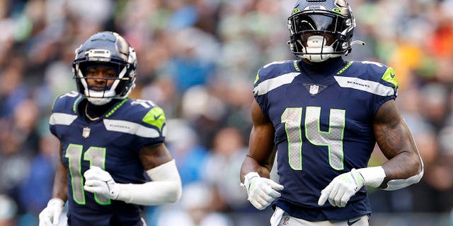 Marquis Goodwin, #11, and DK Metcalf, #14, of the Seattle Seahawks jog for their positions during the 3rd quarter against the Carolina Panthers at Lumen Field on December 11, 2022 in Seattle.