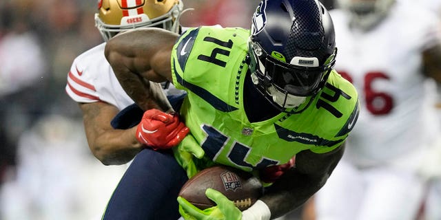 DK Metcalf, #14 of the Seattle Seahawks, carries the ball against the San Francisco 49ers during the second quarter of a game at Lumen Field on December 15, 2022 in Seattle.