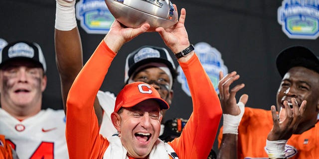 Clemson coach Dabo Swinney holds up the trophy after the team's win over North Carolina in the Atlantic Coast Conference championship game, Saturday, Dec. 3, 2022, in Charlotte, North Carolina.