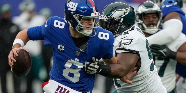 New York Giants quarterback Daniel Jones, #8, is pressured by Philadelphia Eagles defensive tackle Fletcher Cox, #91, during the second quarter of an NFL football game, Sunday, Dec. 11, 2022, in East Rutherford, New Jersey. 