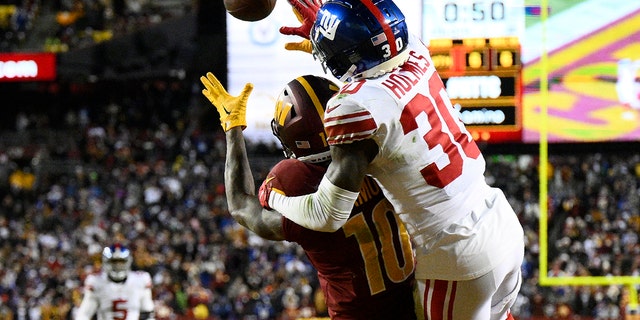 New York Giants cornerback Darnay Holmes (30) defends Washington Commanders wide receiver Curtis Samuel (10) on fourth down to seal a 20-12 victory, Sunday, Dec. 18, 2022, in Landover, Md. 