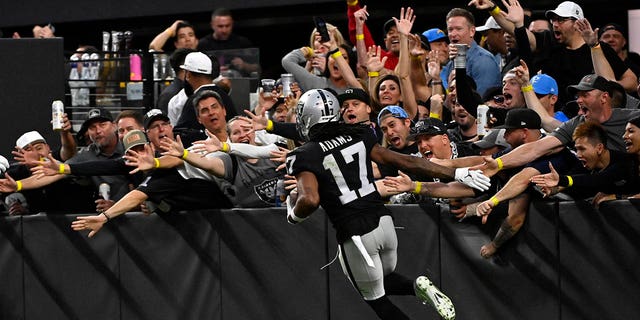 Las Vegas Raiders wide receiver Davante Adams (17) celebrates his touchdown reception as he runs past fans during the second half of an NFL football game against the Los Angeles Chargers, Sunday, Dec. 4, 2022, in Las Vegas. 