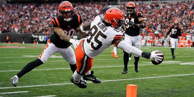 Cleveland Browns' David Njoku (85) reaches for a touchdown against Cincinnati Bengals' Jessie Bates III (30) during the second half of an NFL football game, Sunday, Dec. 11, 2022, in Cincinnati.