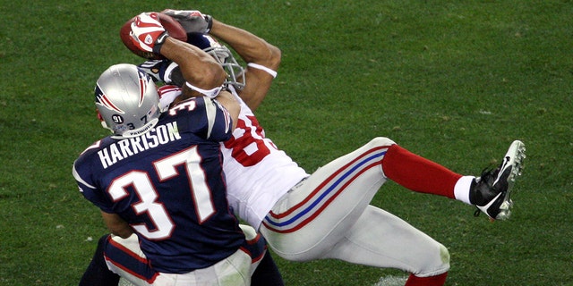 New York Giants' wide receiver David Tyree pins the ball to his helmet as he catches a 32-yard pass late in the fourth quarter of Super Bowl XLII against the New England Patriots at the University of Phoenix Stadium.