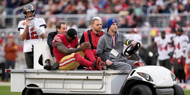 Tampa Bay Buccaneers quarterback Tom Brady, top left, reacts as San Francisco 49ers wide receiver Deebo Samuel, center, during the first half of an NFL football game in Santa Clara, Calif. on Sunday, December 11, 2022. being carted off the field.