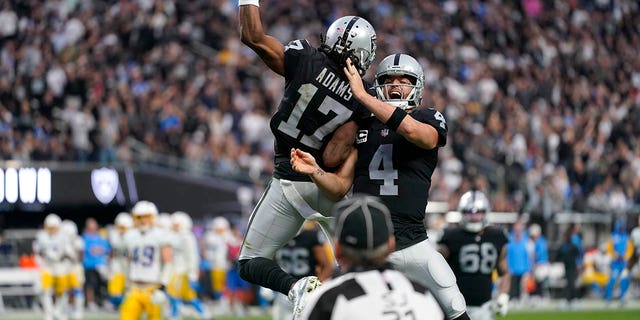 Las Vegas Raiders quarterback Derek Carr (4) and wide receiver Davante Adams (17) celebrate their touchdown during the second half of an NFL football game against the Los Angeles Chargers, Sunday, Dec. 4, 2022, in Las Vegas. 