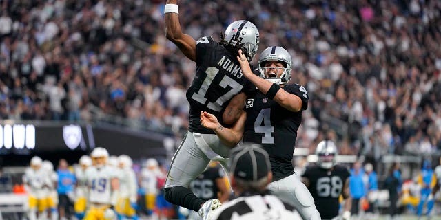 Las Vegas Raiders quarterback Derek Carr (4) and wide receiver Davante Adams (17) celebrate their touchdown during the second half of an NFL football game against the Los Angeles Chargers, Sunday, Dec. 4, 2022, in Las Vegas.