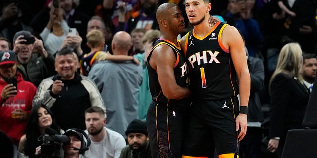 Suns' Chris Paul embraces Devin Booker after his teammate made a basket against the New Orleans Pelicans, Saturday, Dec. 17, 2022, in Phoenix.