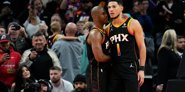 Suns' Chris Paul embraces Devin Booker after his teammate made a basket against the New Orleans Pelicans, Saturday, Dec. 17, 2022, in Phoenix.