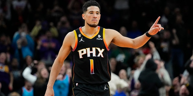 Phoenix Suns guard Devin Booker reacts to a basket during the second half of an NBA basketball game against the New Orleans Pelicans, Saturday, Dec. 17, 2022, in Phoenix.