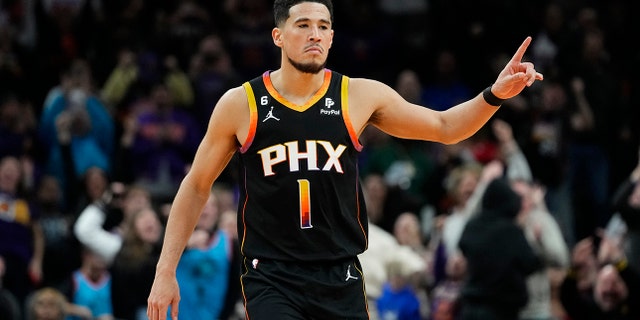 Phoenix Suns guard Devin Booker reacts to a basket during the second half of an NBA basketball game against the New Orleans Pelicans, Saturday, Dec. 17, 2022, in Phoenix.