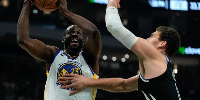 Golden State Warriors' Draymond Green shoots past Bucks' Brook Lopez, Tuesday, Dec. 13, 2022, in Milwaukee. 