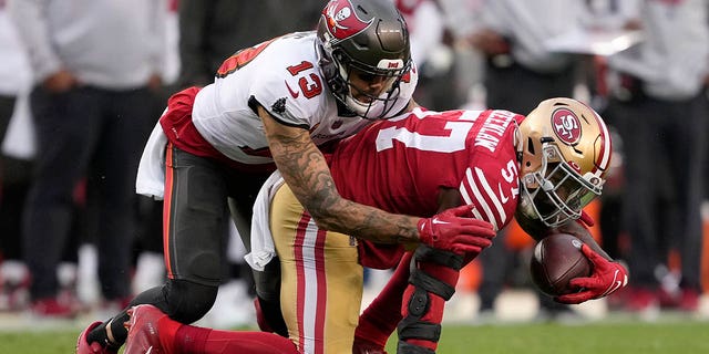 San Francisco 49ers linebacker Dre Greenlaw, right, intercepts a pass in front of Tampa Bay Buccaneers wide receiver Mike Evans during the second half in Santa Clara, California, Sunday, Dec. 11, 2022.