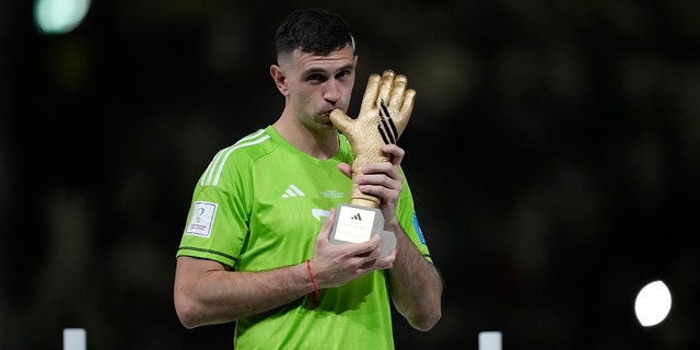 Argentina's goalkeeper Emiliano Martinez kisses his Golden Glove award, Sunday, Dec. 18, 2022.