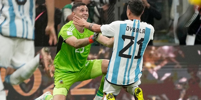 Argentina's Paulo Dybala and goalkeeper Emiliano Martinez react after winning the World Cup final match against France at the Lusail Stadium in Lusail, Qatar, Sunday, Dec. 18, 2022.