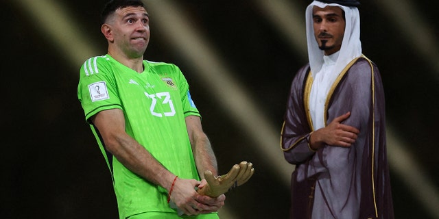 Argentina's Emiliano Martinez reacts after receiving the Golden Glove award after the match.