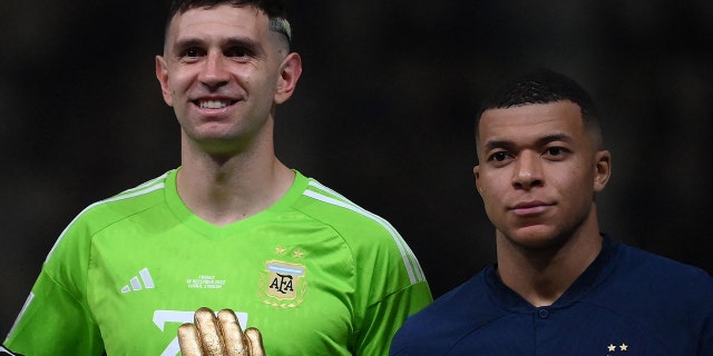 Emiliano Martínez de Argentina y Kylian Mbappé de Francia posan después de los premios durante la ceremonia de entrega de trofeos de la Copa Mundial de Qatar.