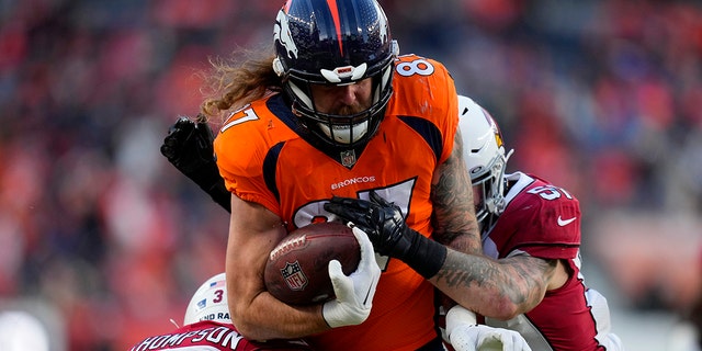 Denver Broncos tight end Eric Tomlinson (87) is hit by Arizona Cardinals safety Jalen Thompson (34) during the second half of an NFL football game, Sunday, Dec. 18, 2022, in Denver.