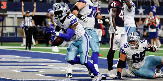 Dallas Cowboys running back Ezekiel Elliott (21) scores a touchdown during the second half of a game against the Houston Texans on December 11, 2022 in Arlington, Texas. 