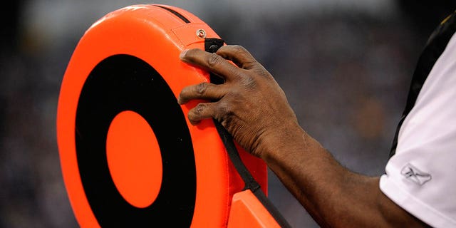 A member of the chain crew adjusts the first down marker during a game.