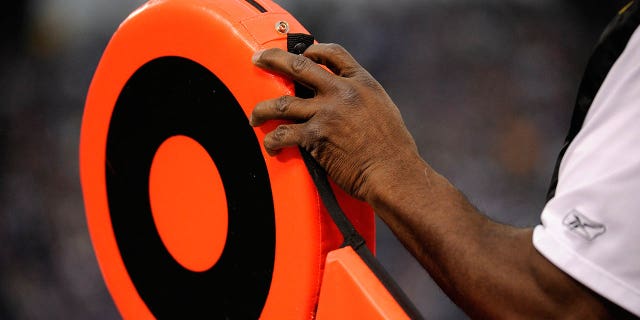 A member of the chain crew adjusts the first down marker during a game.