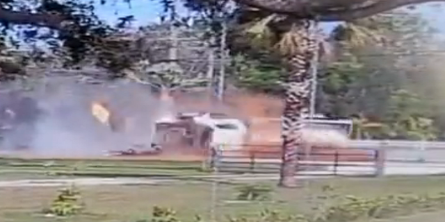 Two individuals are seen emerging from the cab of the truck as it slides down the road in Fort Myers, Florida.