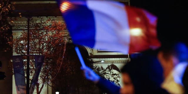 The French flag is displayed at night.