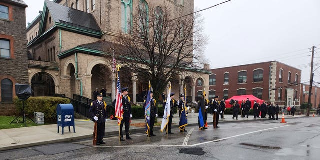 La policía se encuentra en una guardia de honor por los caídos El Sargento de Policía de Yonkers.  Frank Gualdino, cuya misa fúnebre se celebró en la Iglesia del Sagrado Corazón en Yonkers, Nueva York, el 7 de diciembre de 2022.
