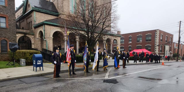 La policía se encuentra en una guardia de honor por los caídos El Sargento de Policía de Yonkers.  Frank Gualdino, cuya misa fúnebre se celebró en la Iglesia del Sagrado Corazón en Yonkers, Nueva York, el 7 de diciembre de 2022.