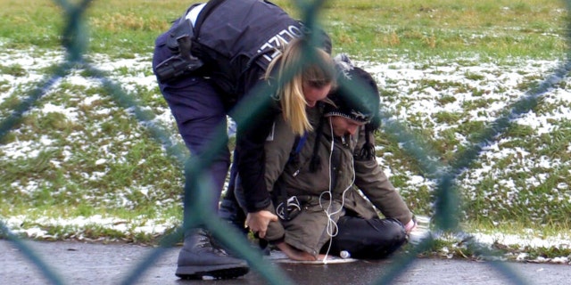 A Federal Police officer tries to remove a 'Last Generation' activist from a street at the BER Airport in Berlin, Germany, Thursday, Dec. 8, 2022. 