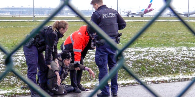 A Federal Police officer tries to remove a 'Last Generation' activist from a street at the BER Airport in Berlin, Germany, Thursday, Dec. 8, 2022. 