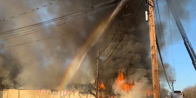 A rainbow appears as firefighters fight a destructive blaze at The Place Church in Gastonia, North Carolina.