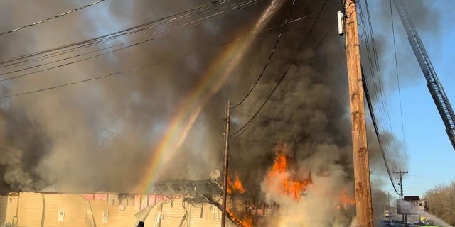 A rainbow appears as firefighters fight a destructive blaze at The Place Church in Gastonia, North Carolina.