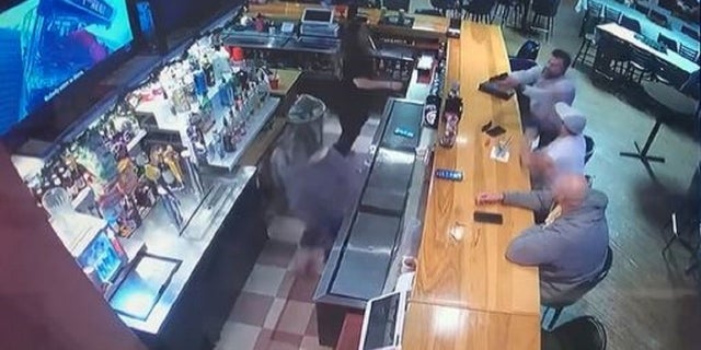Attorney Gavin Rush points a gun at his ex-girlfriend, who is working at a bar in Austin, Texas, before being tackled by two patrons.