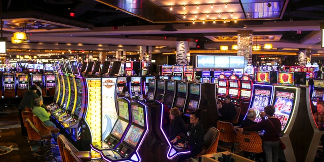 Patrons sit at slot machines inside the MGM Springfield Casino in Springfield, Mass.