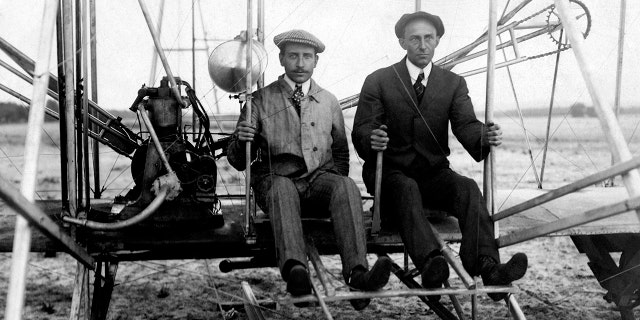 Wilbur and Orville wright are seen on flyer I in 1910.