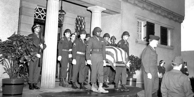 Uniformed pallbearers carry the flag-covered casket containing the body of military commander George S. Patton (1885-1945) from the Villa Rainer, after which it was transported to Christ Church for the funeral, Heidelberg, Germany, Dec. 23, 1945. 