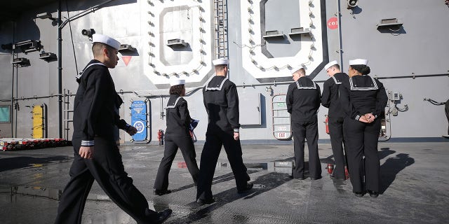 U.S. Navy sailors walk with the flag on the flight deck of the USS Nimitz (CVN 68) aircraft carrier in Coronado, California, on Jan. 18, 2020. The Navy recently has been given congressional approval to raise the maximum enlisted bonus to $75,000, according to Military.com.