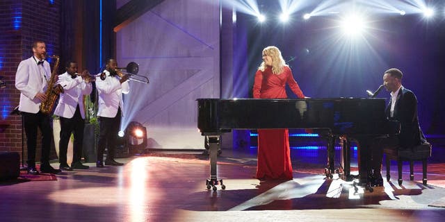 Kelly Clarkson (middle) and John Legend (far right) sing 'Baby, It's Cold Outside' with rewritten lyrics during a stage performance they recorded for ‘The Kelly Clarkson Show’ (Episode 3072) on Nov. 18, 2019.