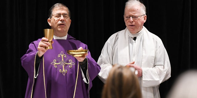 Frank Pavone (at left), the national director of Priests for Life, celebrates Catholic Mass for attendees at the 2021 Conservative Political Action Conference at the Hyatt Regency in Orlando, Florida. Pavone has been "laicized," or defrocked, by the Catholic Church.