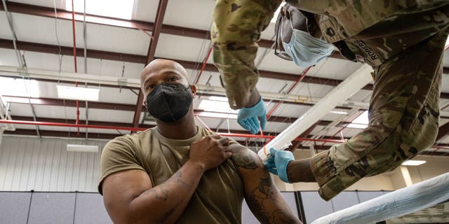Preventative Medicine Services NCOIC Sergeant First Class Demetrius Roberson administers a COVID-19 vaccine to a soldier on September 9, 2021 in Fort Knox, Kentucky. (Photo by Jon Cherry/Getty Images)