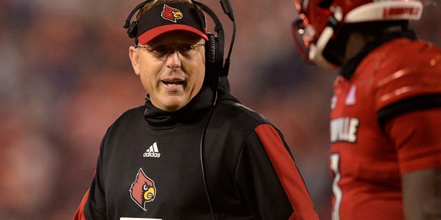 Umqeqeshi oyinhloko we-Louisville Cardinals uScott Satterfield uxoxa nomdlali wasemuva uMalik Cunningham (3) njengoba bephuma enkundleni ngesikhathi bebhekene neClemson Tigers Nov. 6, 2021, eCardinal Stadium e-Louisville, Ky.