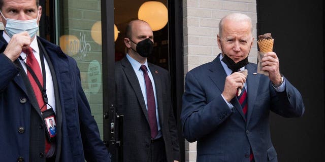 President Joe Biden carries an ice cream cone as he leaves Jeni's Ice Cream in Washington, D.C., on Jan. 25, 2022.