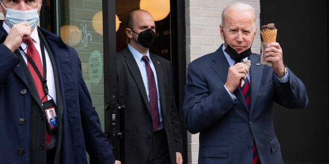 El presidente Joe Biden lleva un cono de helado cuando sale de Jeni's Ice Cream en Washington, DC, el 25 de enero de 2022.