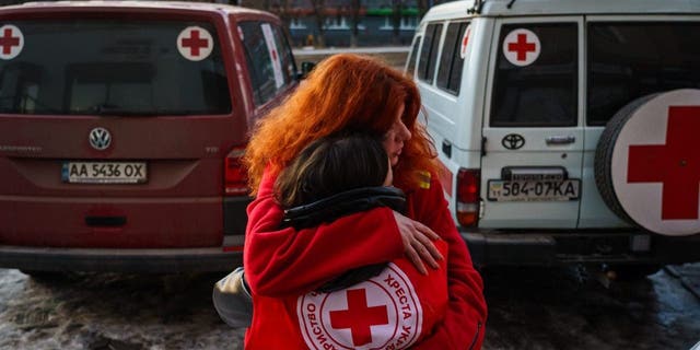 Red Cross workers embrace each other after a resupply mission to residents who cannot leave their homes in Kharkiv, Ukraine, March 22, 2022. 