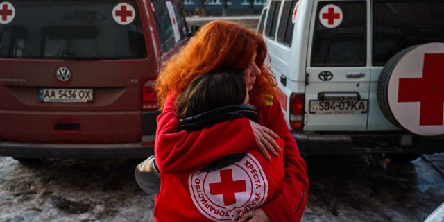 Red Cross workers embrace each other after a resupply mission to residents who cannot leave their homes in Kharkiv, Ukraine, March 22, 2022.