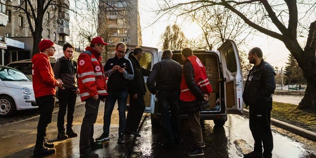 Red Cross workers load supplies into a vehicle before leaving for an operation in Kharkiv, Ukraine, March 24, 2022. 