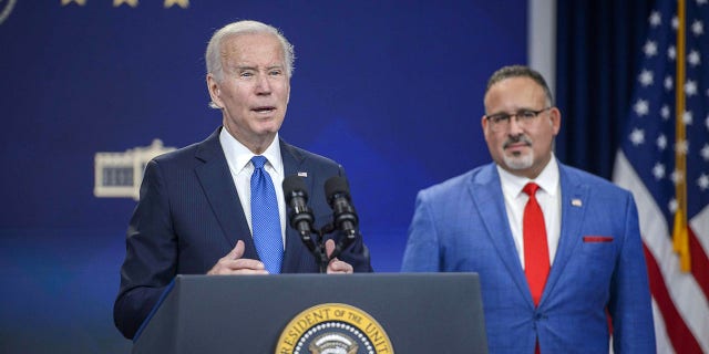 President Joe Biden speaks on his student loan handout as Education Secretary Miguel Cardona listens at the White House campus on Oct. 17, 2022.