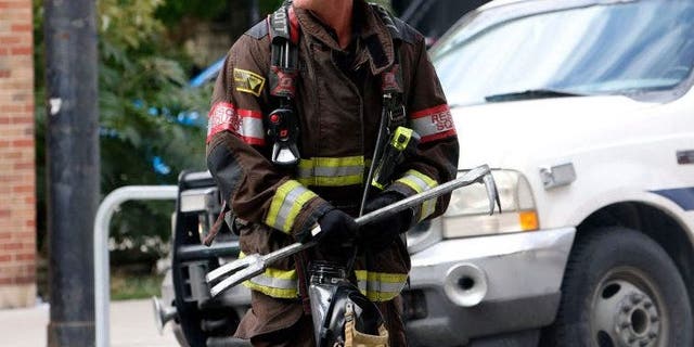 A firefighter portrayed on the show ‘Chicago Fire’ carries a Halligan pry bar, a forcible entry tool used by firefighters.
